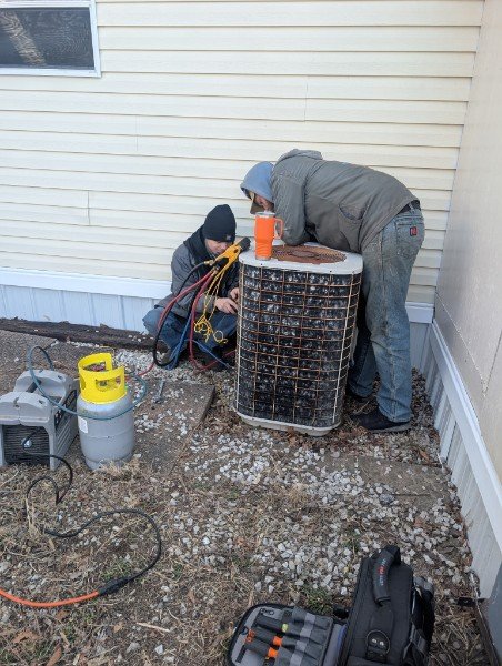HVAC technicians servicing an outdoor condenser
