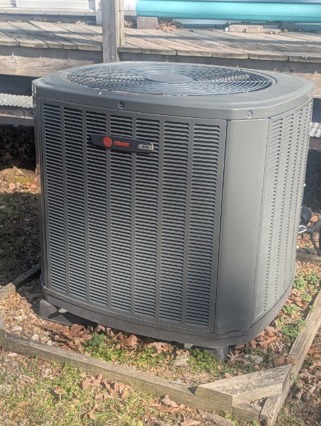 Residential air conditioning condenser in a landscaped yard